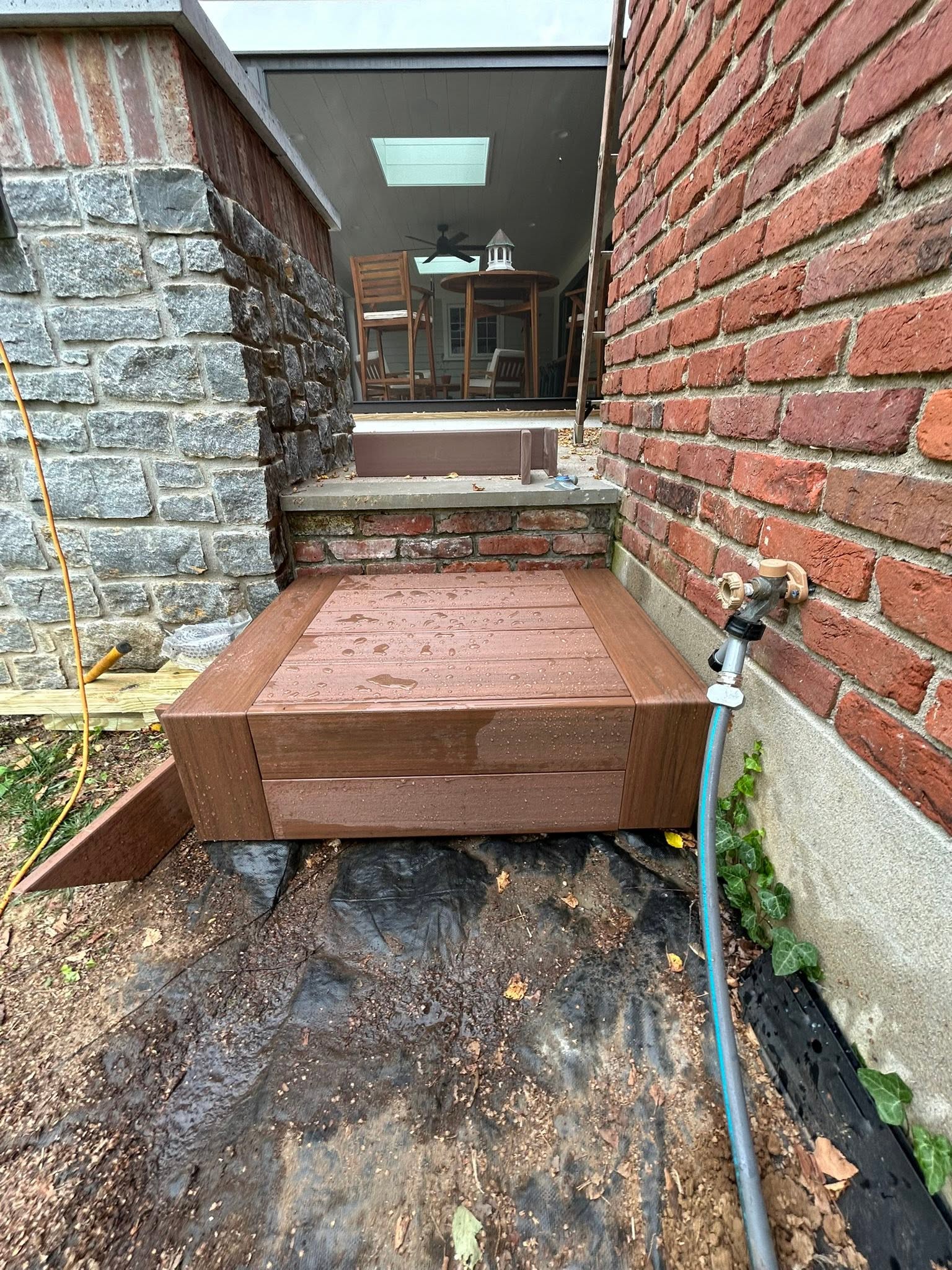Small entry landing between stone and brick walls outside a home
