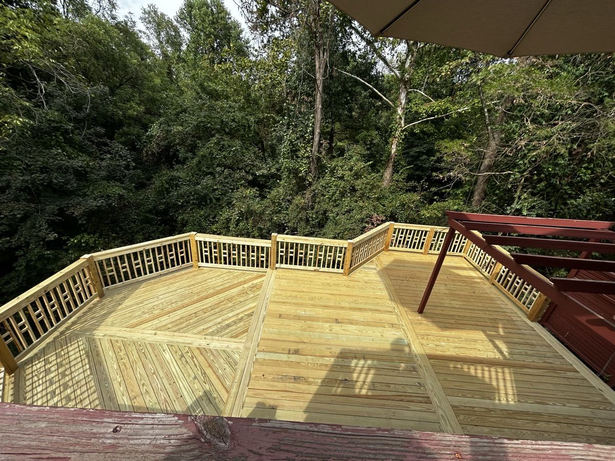 Overhead view of patterned timber decking with railings and wooded surroundings