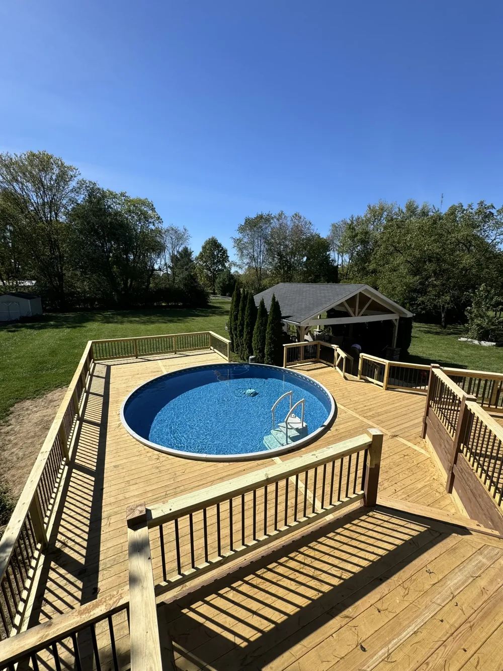 An elevated view of a timber deck surrounding a backyard pool